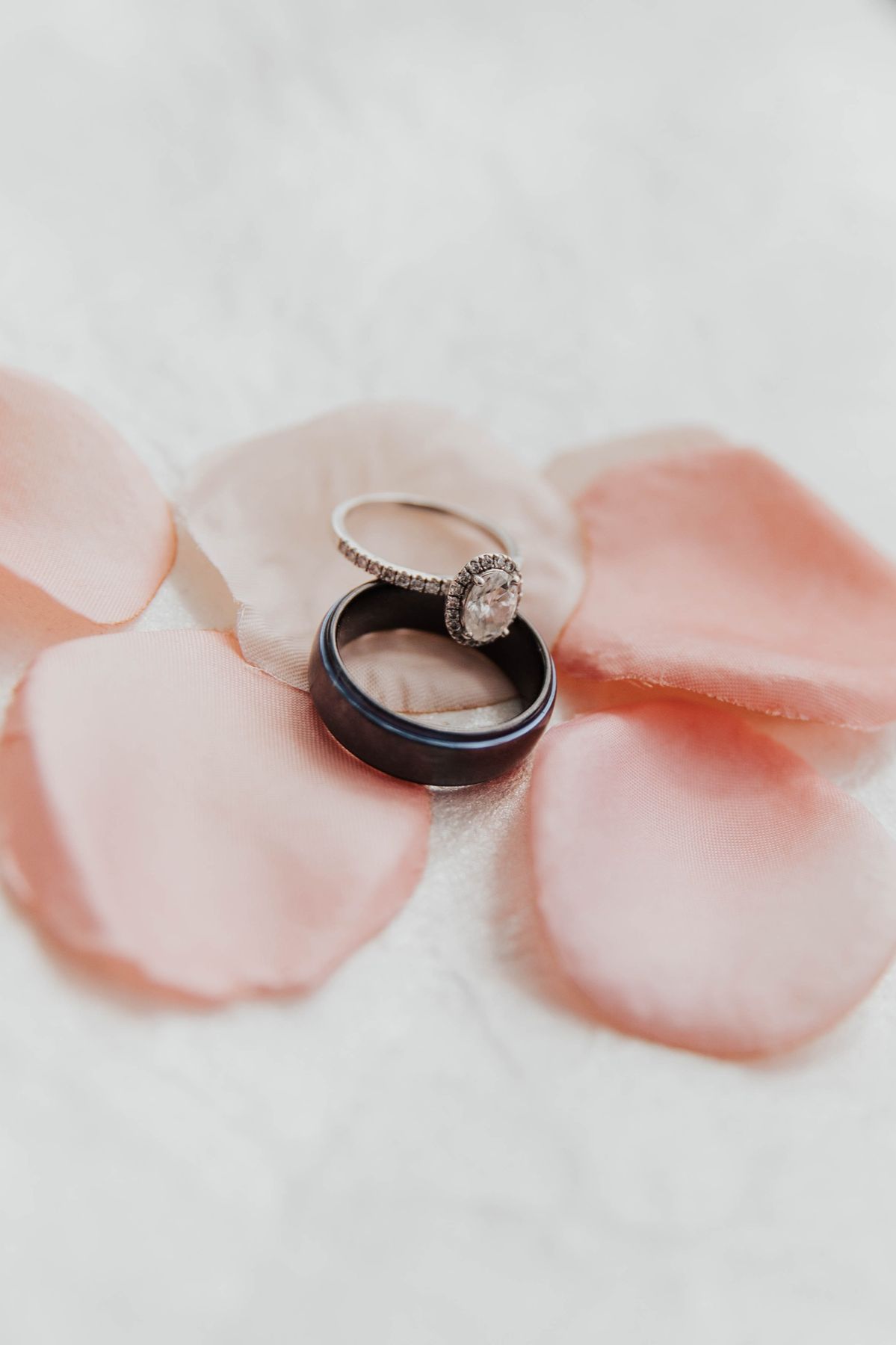 Wedding rings resting on rose petals