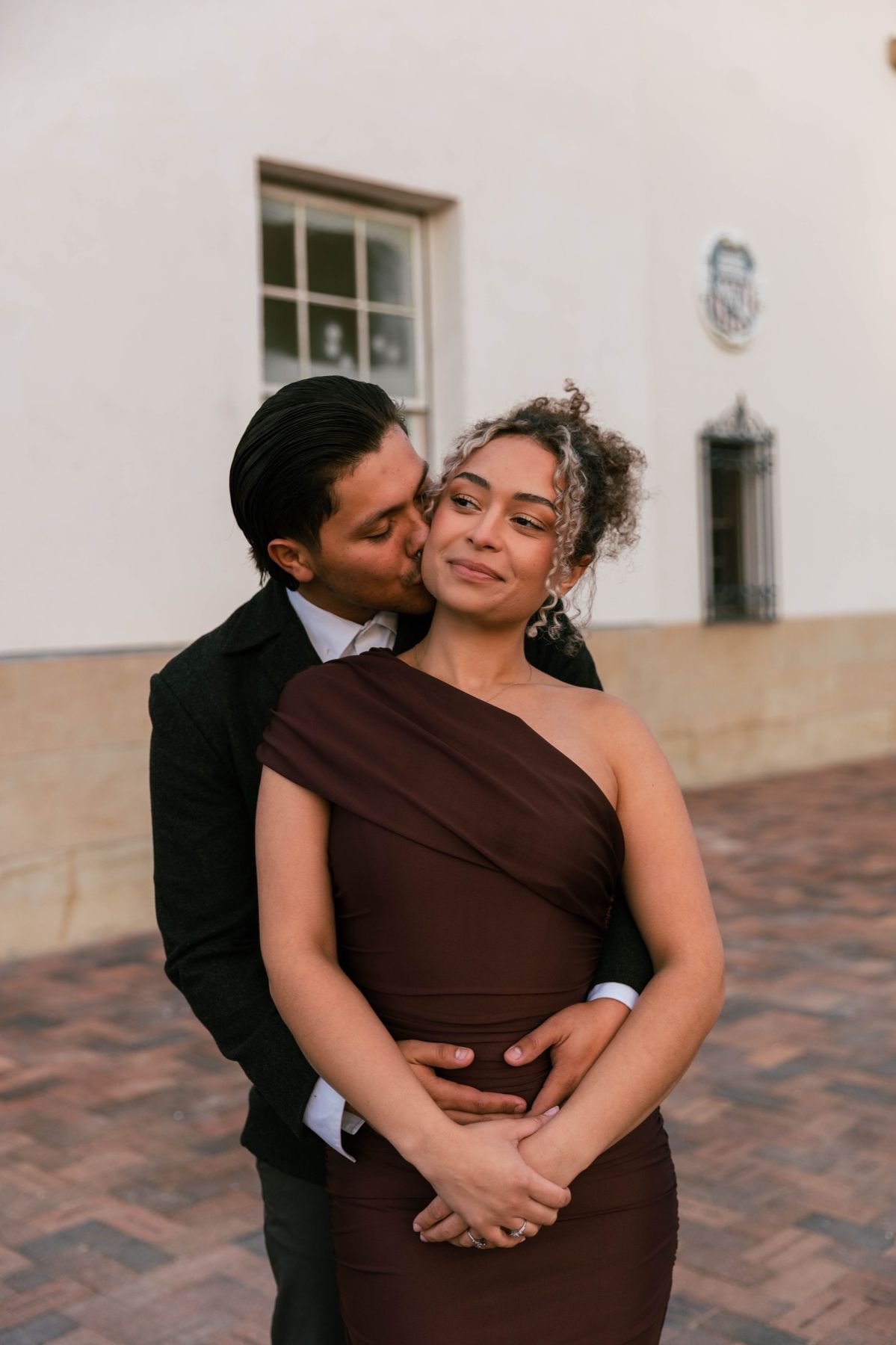 A kiss on the cheek outside the old mission